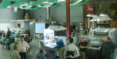 Expo attendees watch the Sakurai Oliver 466SD run waterless printing while others watch a seminar on waterless.
