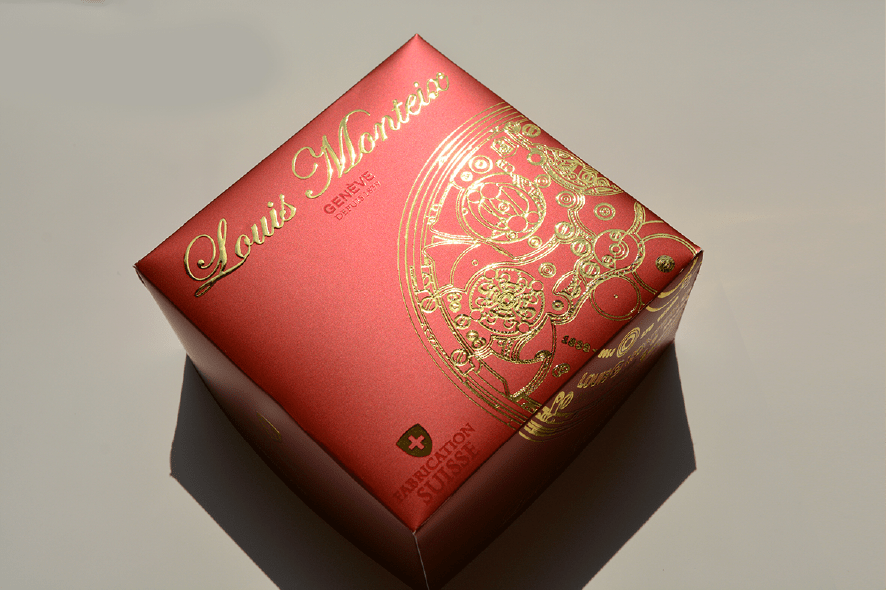 Red luxury packaging box with intricate gold foil embellishment and fine-line ornamental detailing